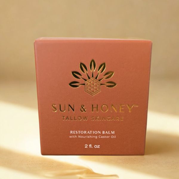 Sun & Honey tallow skincare restoration balm packaging on a beige background