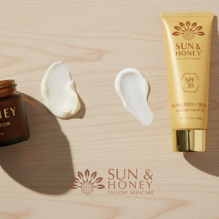 Sun and Honey tallow sunscreen tube and tallow balm jar on a wooden surface.