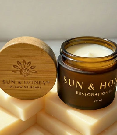 Sun & Honey tallow skincare tallow balm with castor oil with wooden lid and soap bars on a light background
