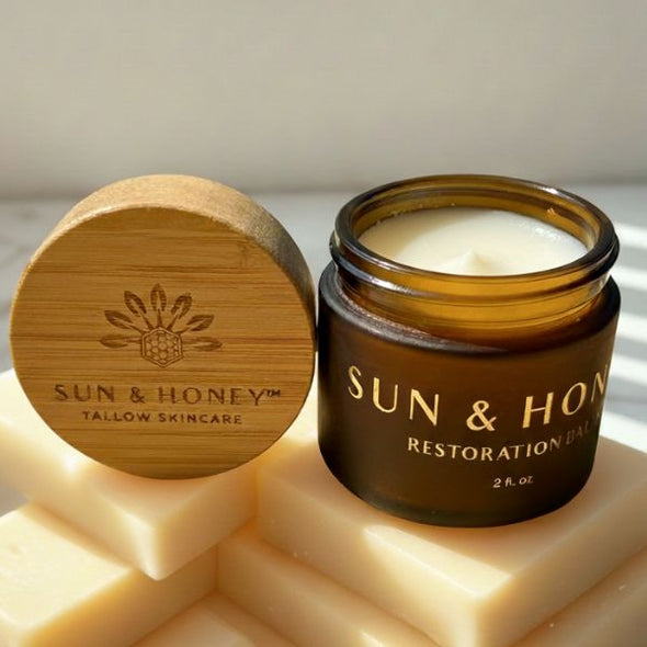 Sun & Honey tallow skincare tallow balm with castor oil with wooden lid and soap bars on a light background